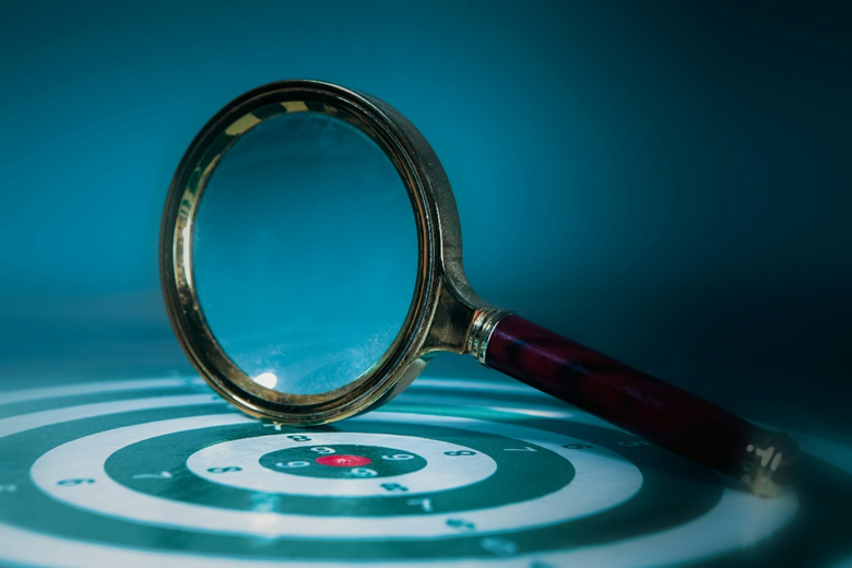 A photo of a magnifying glass representing SEO, GEO and AEO